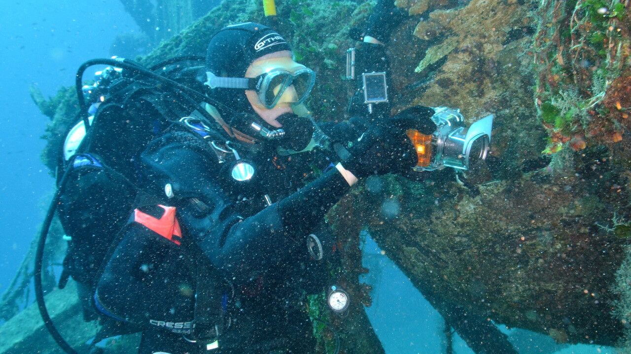 Brian photographing on a wrecked fishing boat, Croatia by Keith Wilson